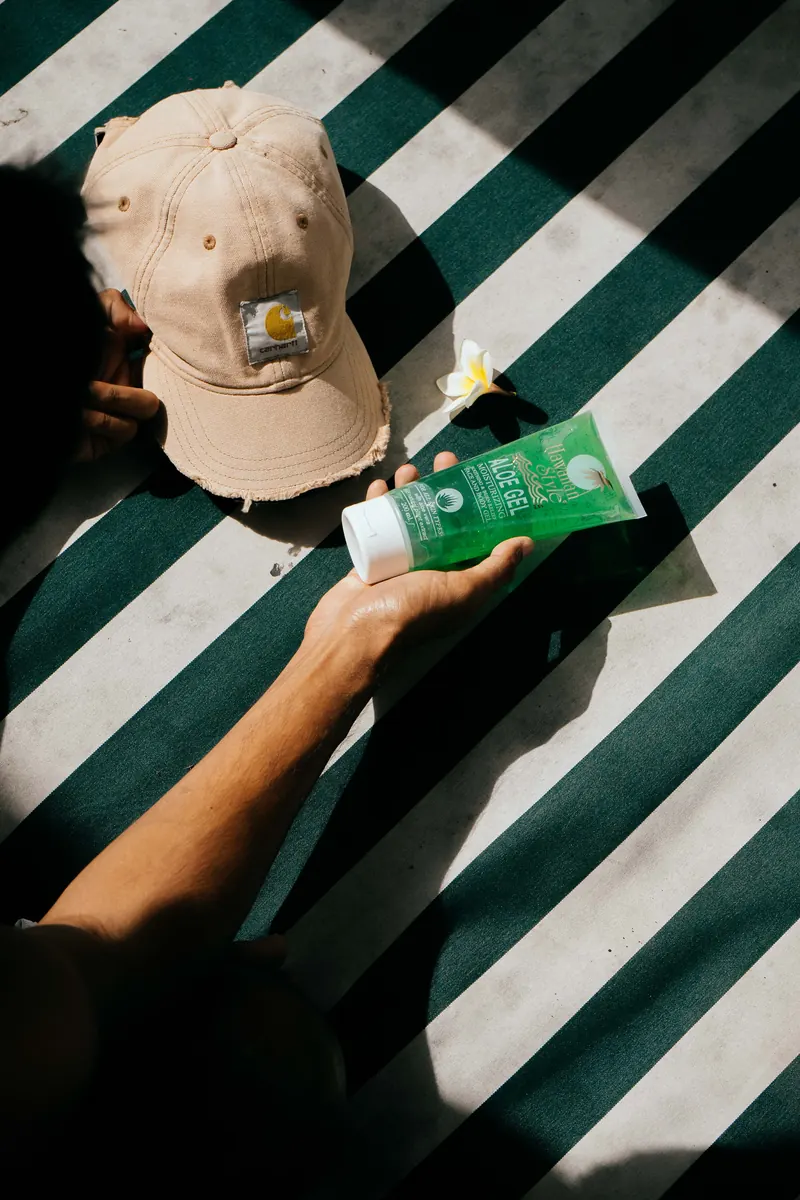 Hawaiian Style Aloe Gel in an overhead flat lay with a cap and a frangipani flower