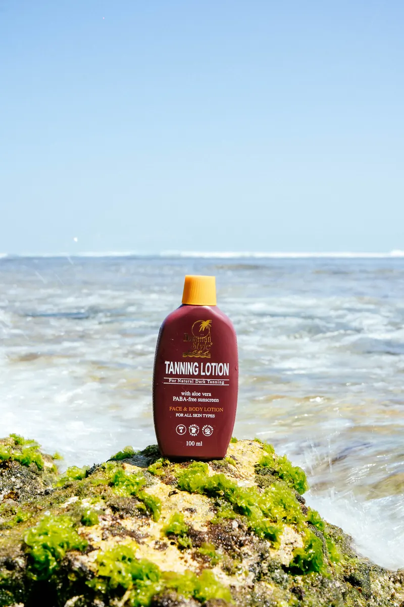 Hawaiian Style Tanning Lotion resting on a sea-tide rock covered in green algae